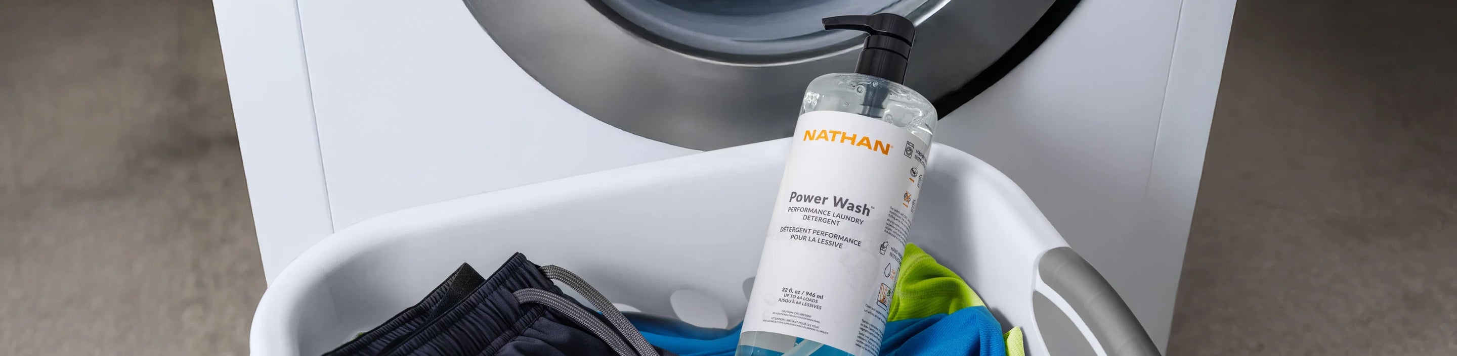 image of laundry basket with couple items of clothing and Nathan Sports bottle of laundry detergent
